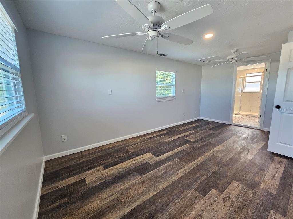 8229 Cypress Road Englewood, FL 34224 - Photo 32 of 44 wooden floor in an empty room with a window