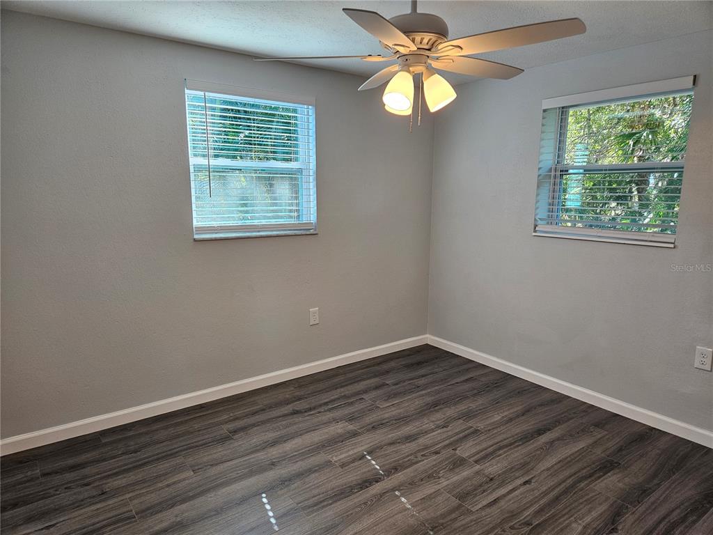 8229 Cypress Road Englewood, FL 34224 - Photo 40 of 44 a view of an empty room with wooden floor and a window