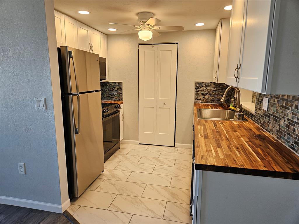 8229 Cypress Road Englewood, FL 34224 - Photo 7 of 44 a kitchen with stainless steel appliances granite countertop a refrigerator and a stove