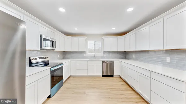 a kitchen with granite countertop white cabinets and white appliances