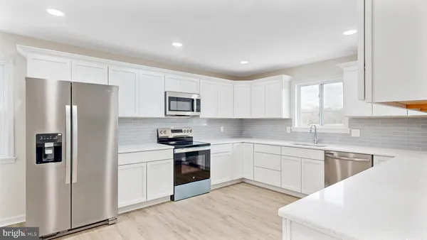 a kitchen with stainless steel appliances granite countertop a refrigerator sink and stove