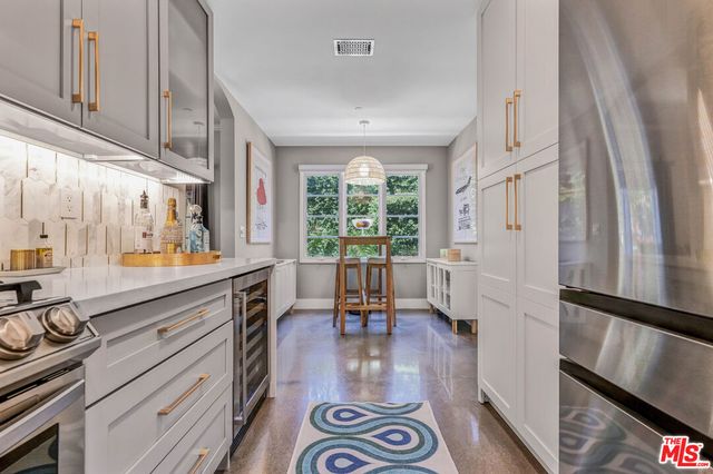 a kitchen with stainless steel appliances a stove a refrigerator and a dining table