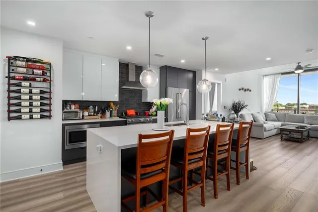 a kitchen with stainless steel appliances a dining table chairs stove and white cabinets