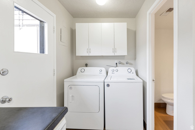 88 West 50 South, Unit J10 Centerville, UT 84014 - Photo 9 of 19 Laundry area featuring white cabinetry, a light-colored countertop, and a windowed exterior door