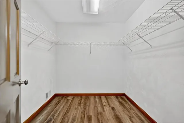 a view of a room with wooden floor and small window