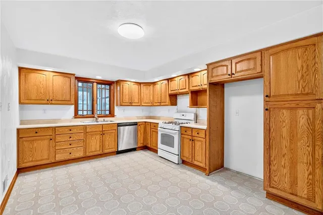a large kitchen with stainless steel appliances granite countertop a refrigerator and a stove top oven