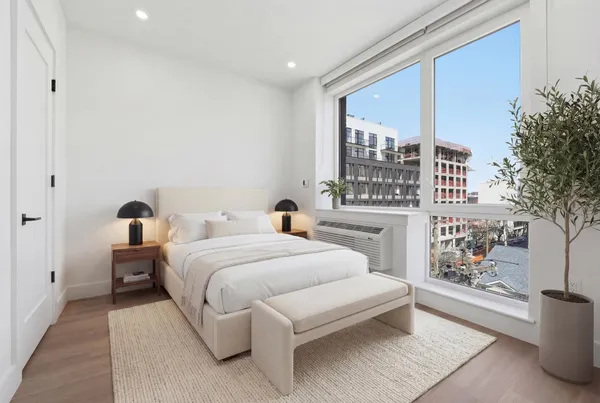 a bedroom with a large bed and a potted plant