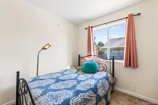 a bed sitting in a bedroom next to a window