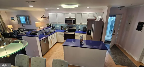 a kitchen with stainless steel appliances granite countertop a refrigerator a stove top oven a sink and dishwasher