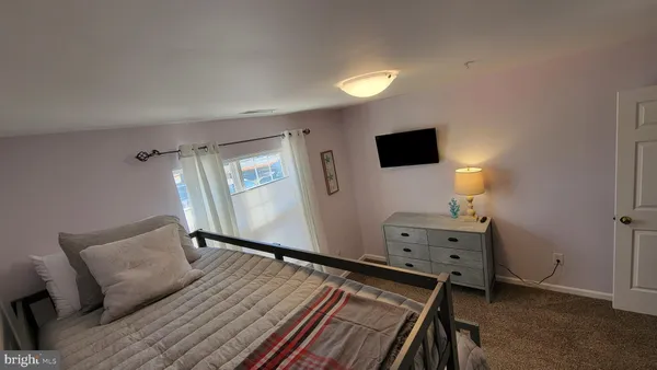 a view of a bedroom with wooden floor and bathroom