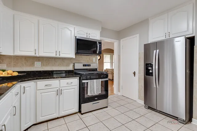 a kitchen with white cabinets and stainless steel appliances