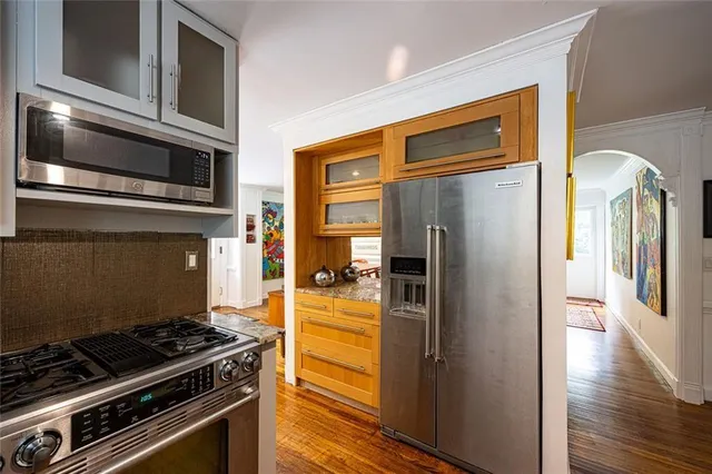 a kitchen with stainless steel appliances granite countertop a refrigerator and a stove top oven