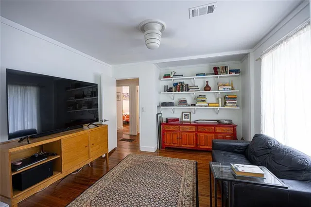a living room with furniture a flat screen tv and closet