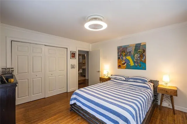a bedroom with a bed and a painting on the wall