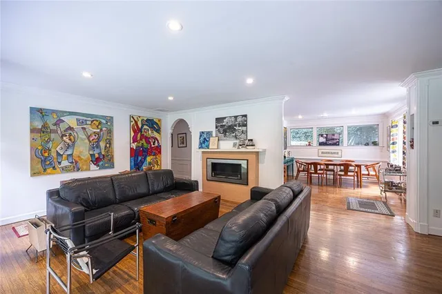 a living room with furniture a fireplace and wooden floor