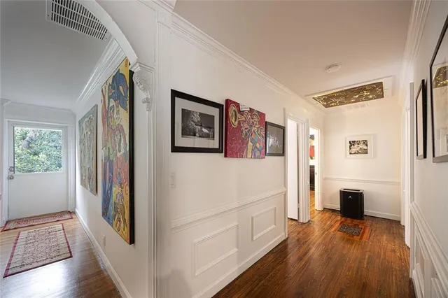 a view of a hallway with wooden floor and furniture
