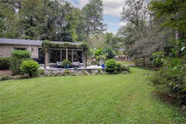 a view of a house with backyard and sitting area