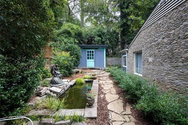 a view of a house with potted plants and large trees