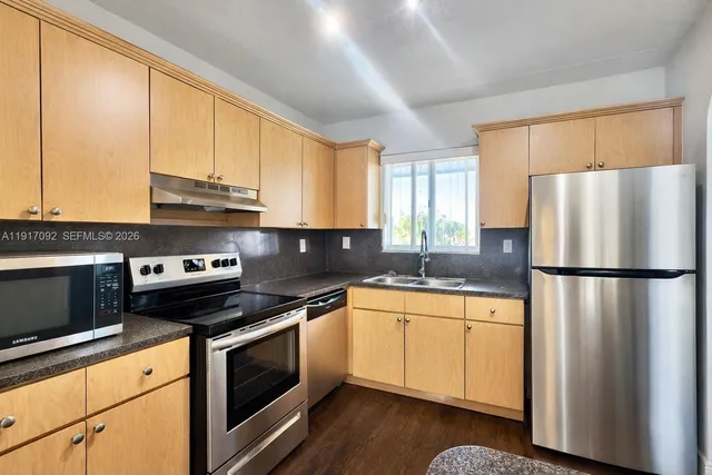 a kitchen with a refrigerator sink and cabinets