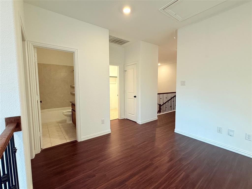 9815 Romo Street Irving, TX 75063 - Photo 19 of 25 an empty room with wooden floor & a mirror