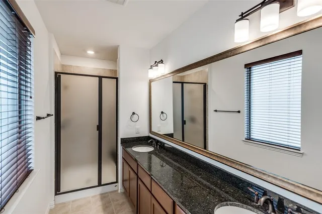 a bathroom with a double vanity sink a mirror and a shower