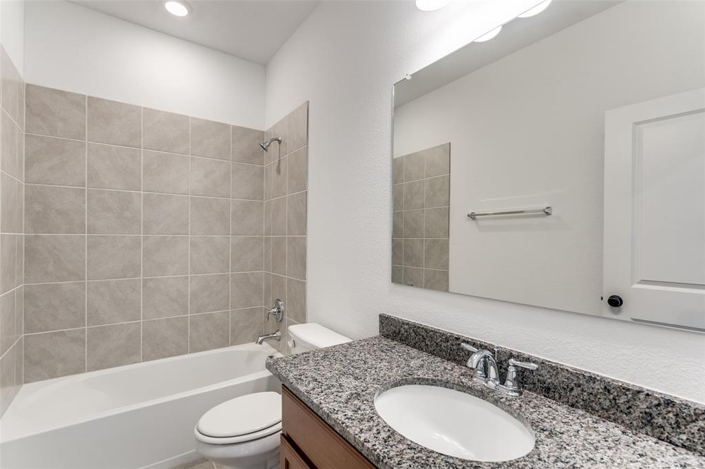 9815 Romo Street Irving, TX 75063 - Photo 23 of 25 a bathroom with a granite countertop sink toilet mirror and bathtub
