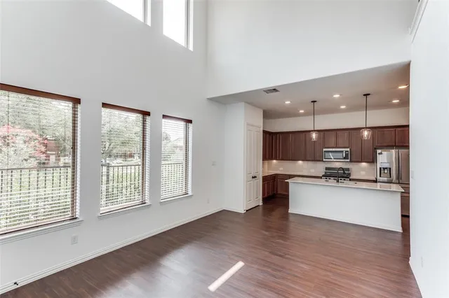 a kitchen with stainless steel appliances kitchen island wooden floors and view living room