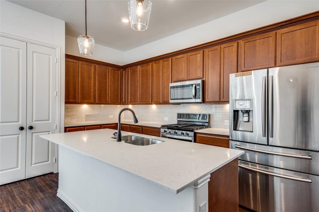 9815 Romo Street Irving, TX 75063 - Photo 5 of 25 a kitchen with stainless steel appliances a refrigerator a sink a stove a microwave and wooden floors