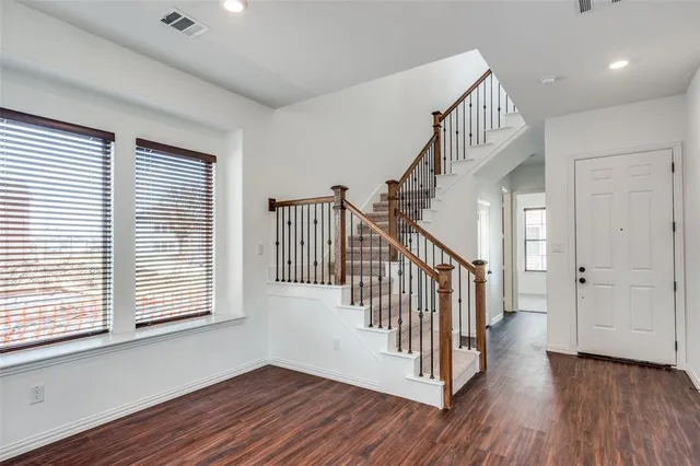 a view of a hallway with wooden floor and windows