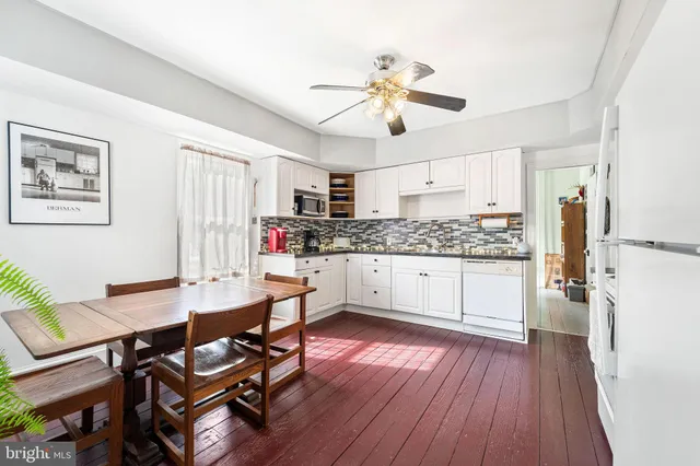a kitchen with stainless steel appliances white cabinets and wooden floor