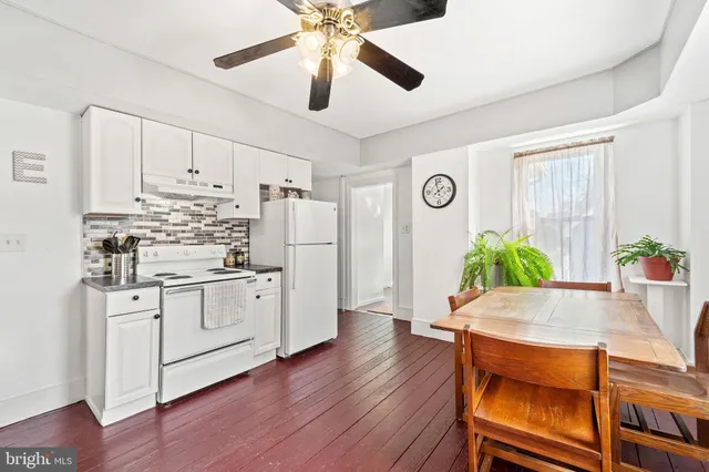 a kitchen with stainless steel appliances white cabinets and wooden floor