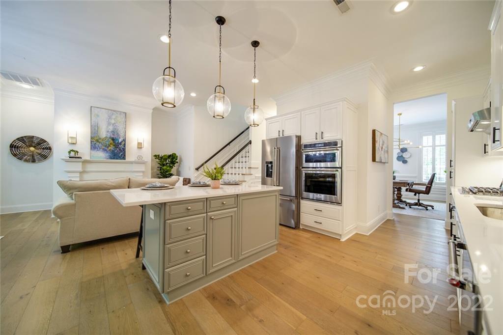6309 Wakehurst Road Charlotte, NC 28226 - Photo 12 of 48 a large white kitchen with a stove a sink a dining table and chairs