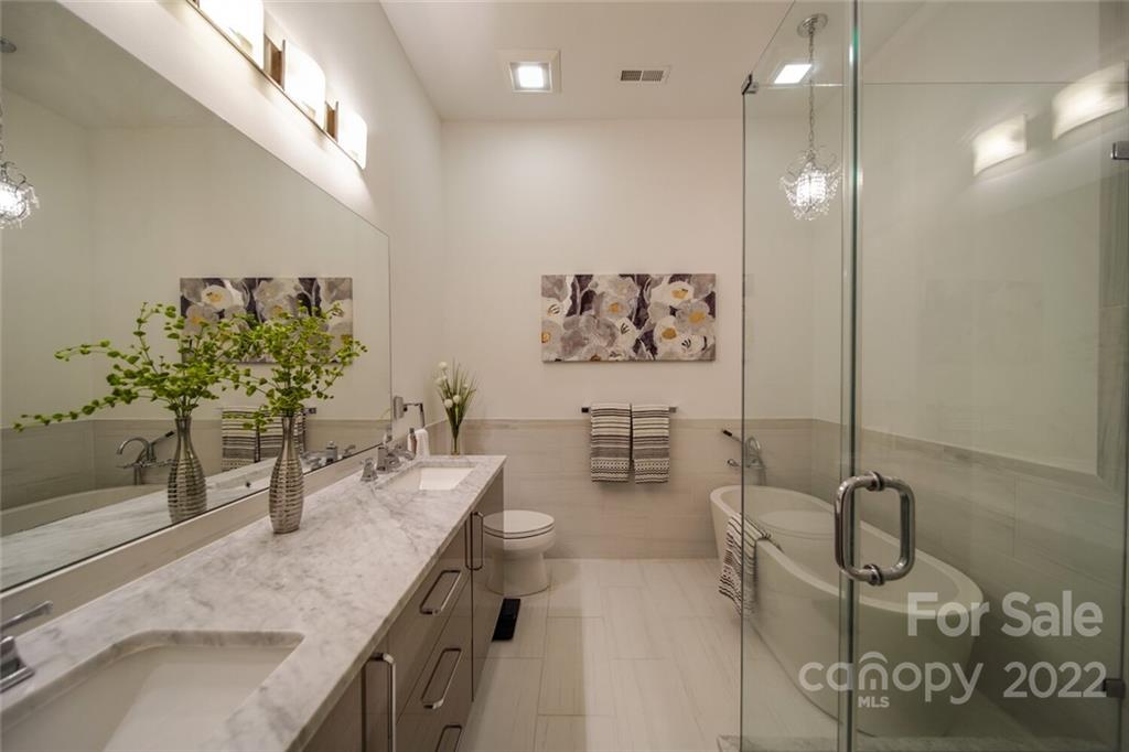 6309 Wakehurst Road Charlotte, NC 28226 - Photo 22 of 48 a bathroom with a granite countertop sink a mirror and shower