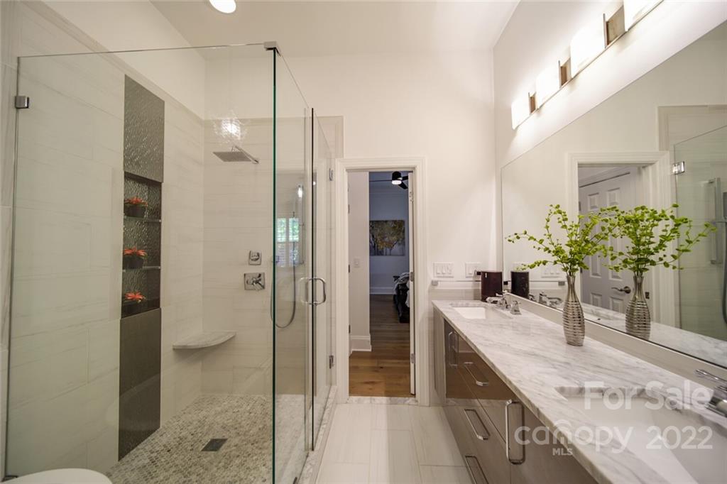 6309 Wakehurst Road Charlotte, NC 28226 - Photo 24 of 48 a bathroom with a granite countertop sink a mirror and a shower