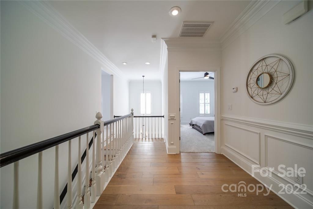 6309 Wakehurst Road Charlotte, NC 28226 - Photo 40 of 48 a hallway with a large mirror a clock and a window