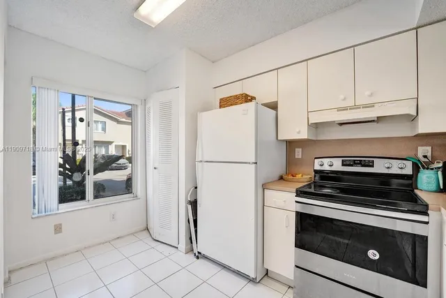 a kitchen with white cabinets and white appliances