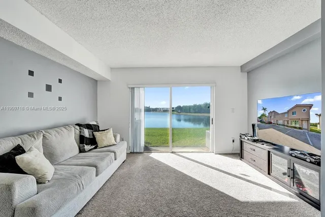 a living room with furniture and a dining table with kitchen view