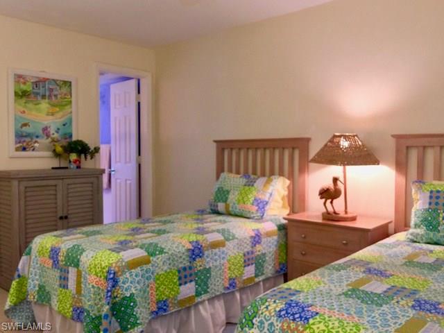 175 5th Avenue South, Unit 104 Naples, FL 34102 - Photo 6 of 9 a bedroom with a bed and a dresser