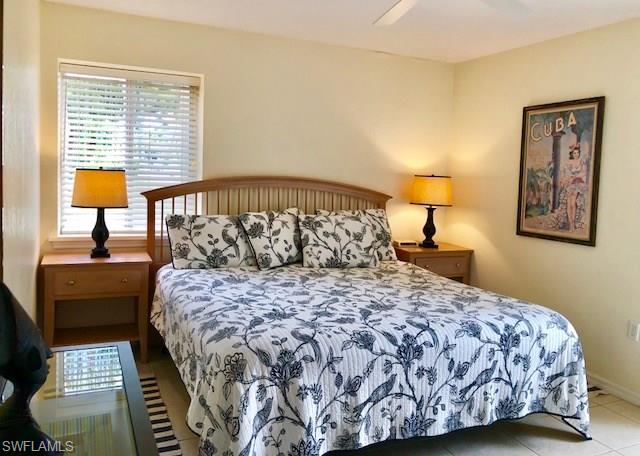 175 5th Avenue South, Unit 104 Naples, FL 34102 - Photo 8 of 9 a large bed sitting in a bedroom next to a lamp