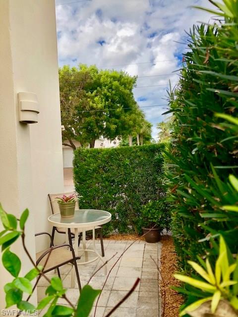 175 5th Avenue South, Unit 104 Naples, FL 34102 - Photo 9 of 9 a backyard with table and chairs and potted plants