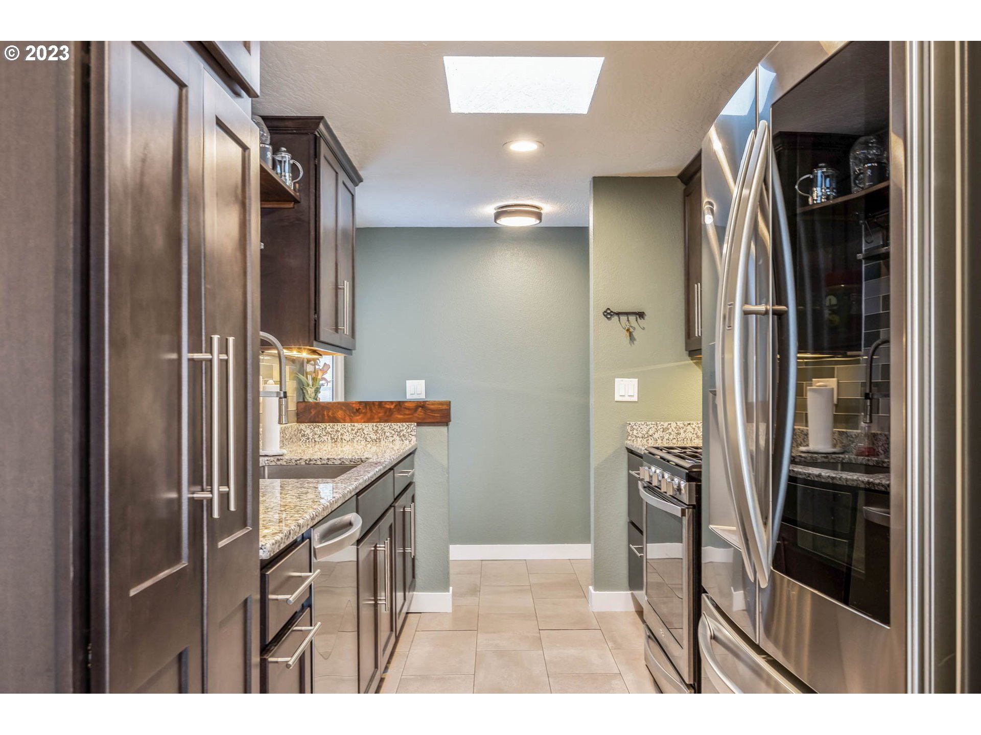 1083 Quinalt Street Springfield, OR 97477 - Photo 12 of 39 a kitchen with stainless steel appliances kitchen island granite countertop a refrigerator and a sink