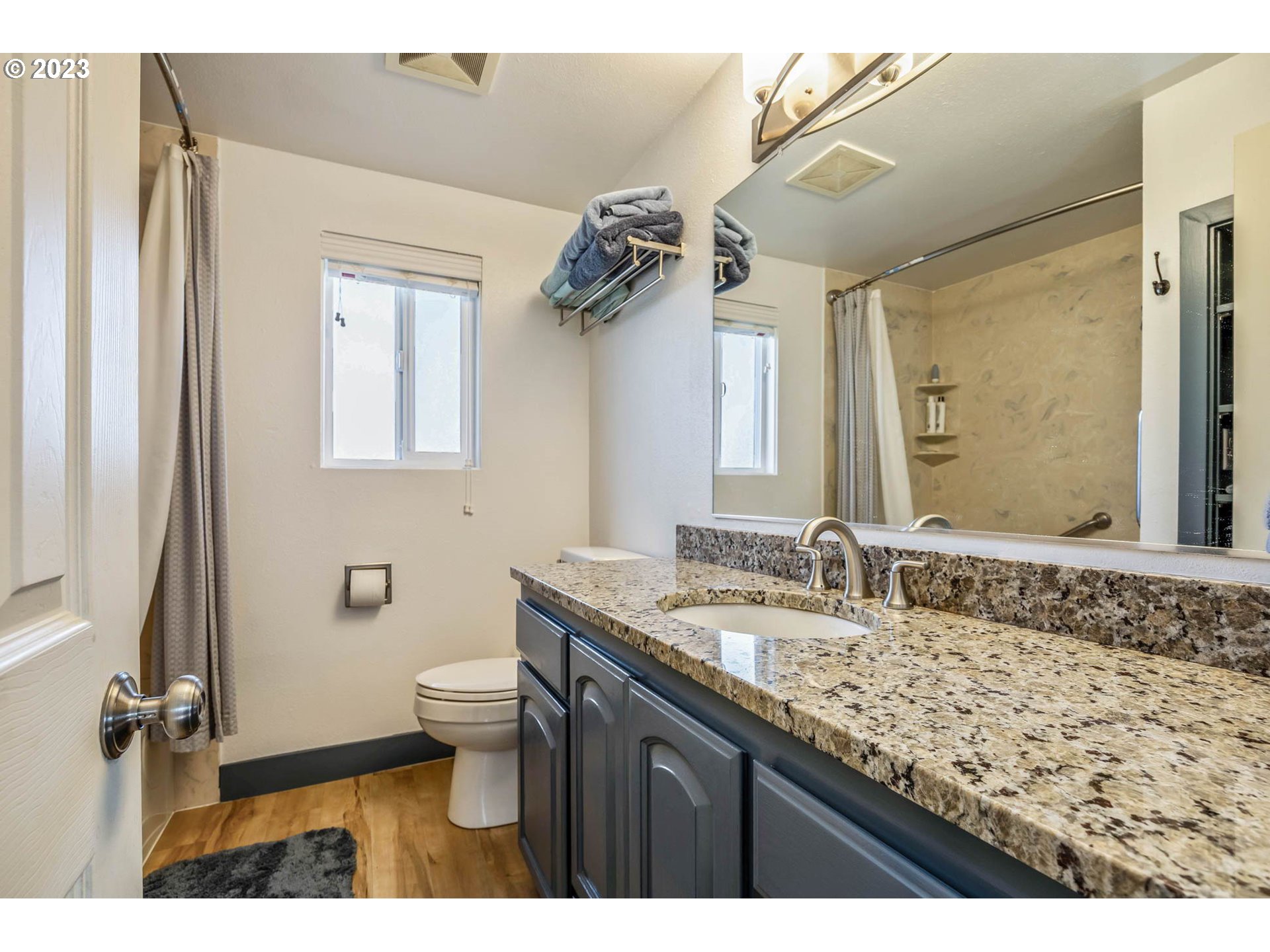 1083 Quinalt Street Springfield, OR 97477 - Photo 23 of 39 a bathroom with a granite countertop sink a mirror and a toilet