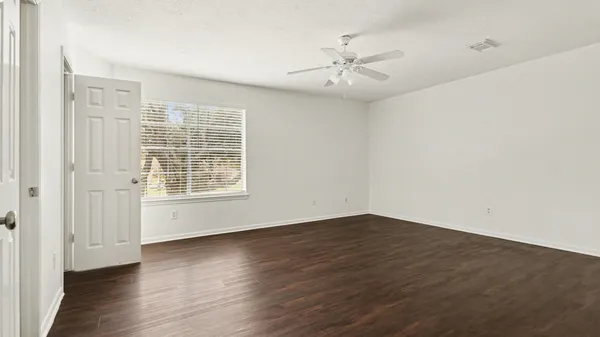 wooden floor in an empty room with a window