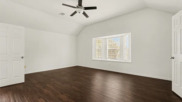 a view of a room with wooden floor and windows