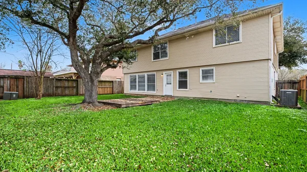 a view of a house with backyard and tree