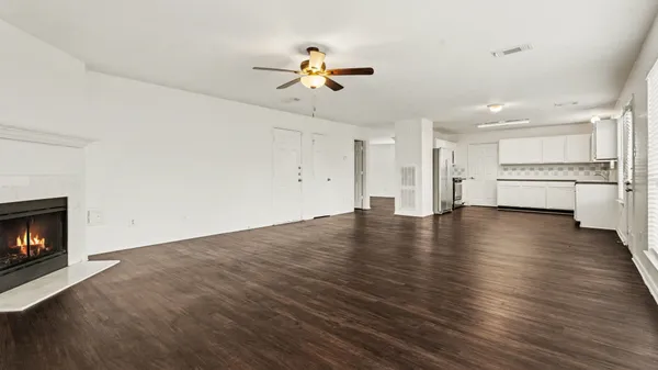 a view of empty room with wooden floor and fireplace
