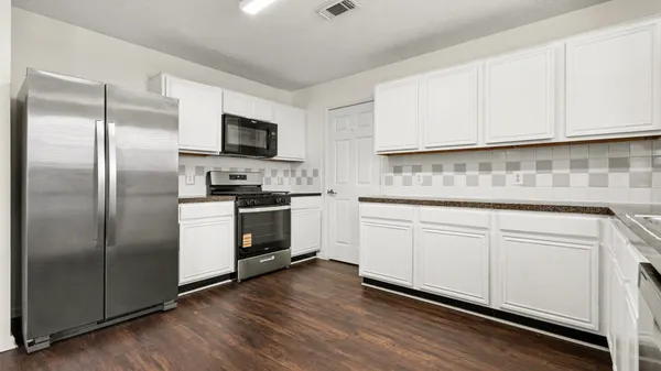 a kitchen with white cabinets stainless steel appliances and sink