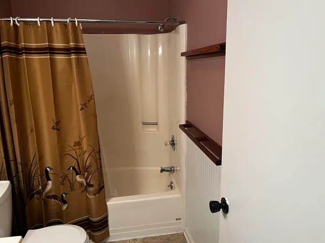 a view of a room with wooden floor and a large window