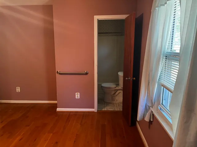 an empty room with wooden floor and closet