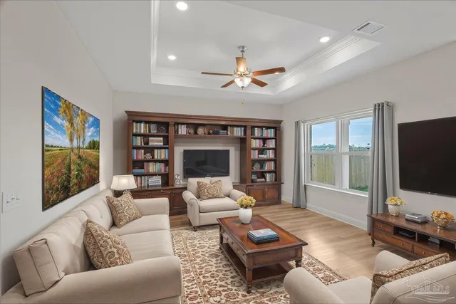 a living room with furniture ceiling fan and a flat screen tv